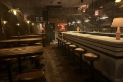 Bar front and top in curved tin white tiles with burgundy detailing