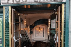 Mixed shades of emerald 6"x6" tiles with tulip border and dado. 6"x6" aged craquelle engobe tiles above