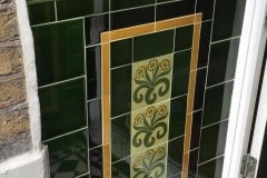 Olive porch design with William Morris green daisies, complete with skirting, tulip border and dado