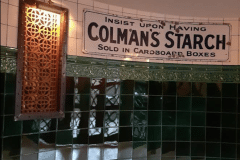 Mixed shades of emerald 6"x6" tiles with tulip border and dado. 6"x6" aged craquelle engobe tiles above