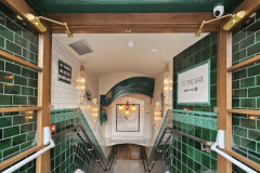 Mixed shades of emerald 6"x6" tiles with tulip border and dado. 6"x6" aged craquelle engobe tiles above