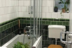 Dark olive plain tiles topped by a tulip border and dado with off white engobe plain tiles above