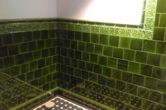 Mixed shades of olive bathroom tiles with tulip border and dado