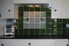 Olive green 6"x6" field tiles with William De Morgan decorate tiles as feature