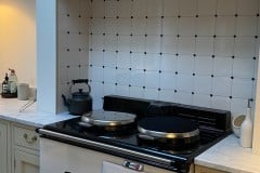 Tin white tiles with clipped corners to accept cast iron studs.